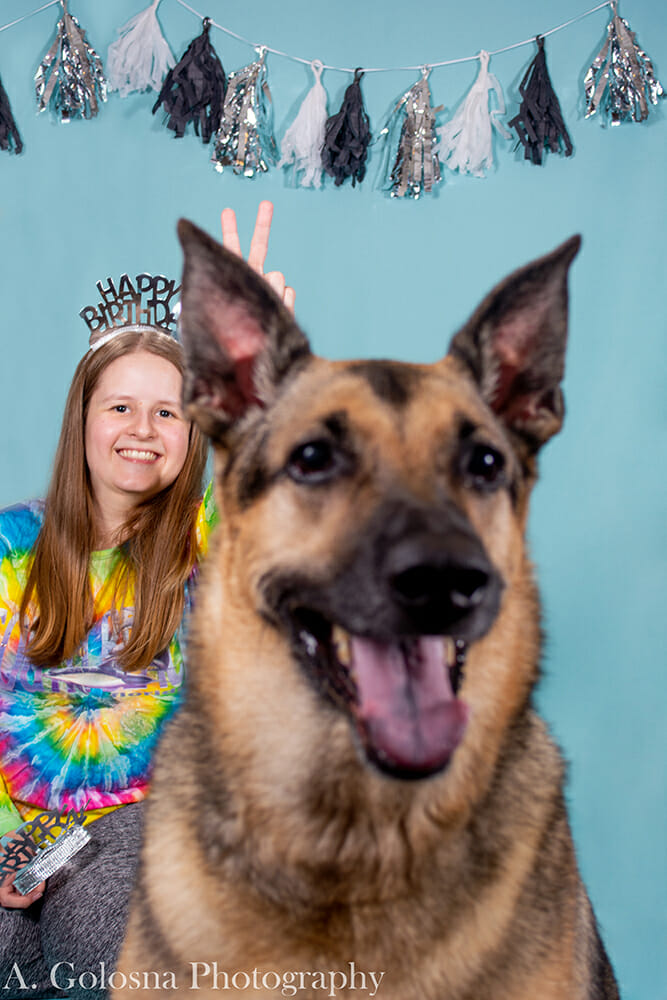 young woman wearing a tierra with her dog also wearing a tierra and getting a pet portrait