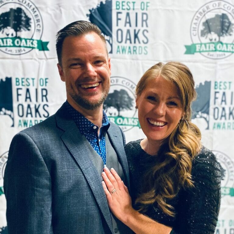 two people posing in front of chamber backdrop