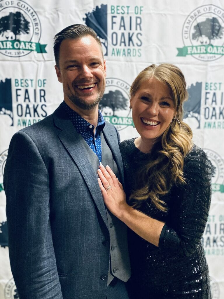 man and woman in front of step and repeat