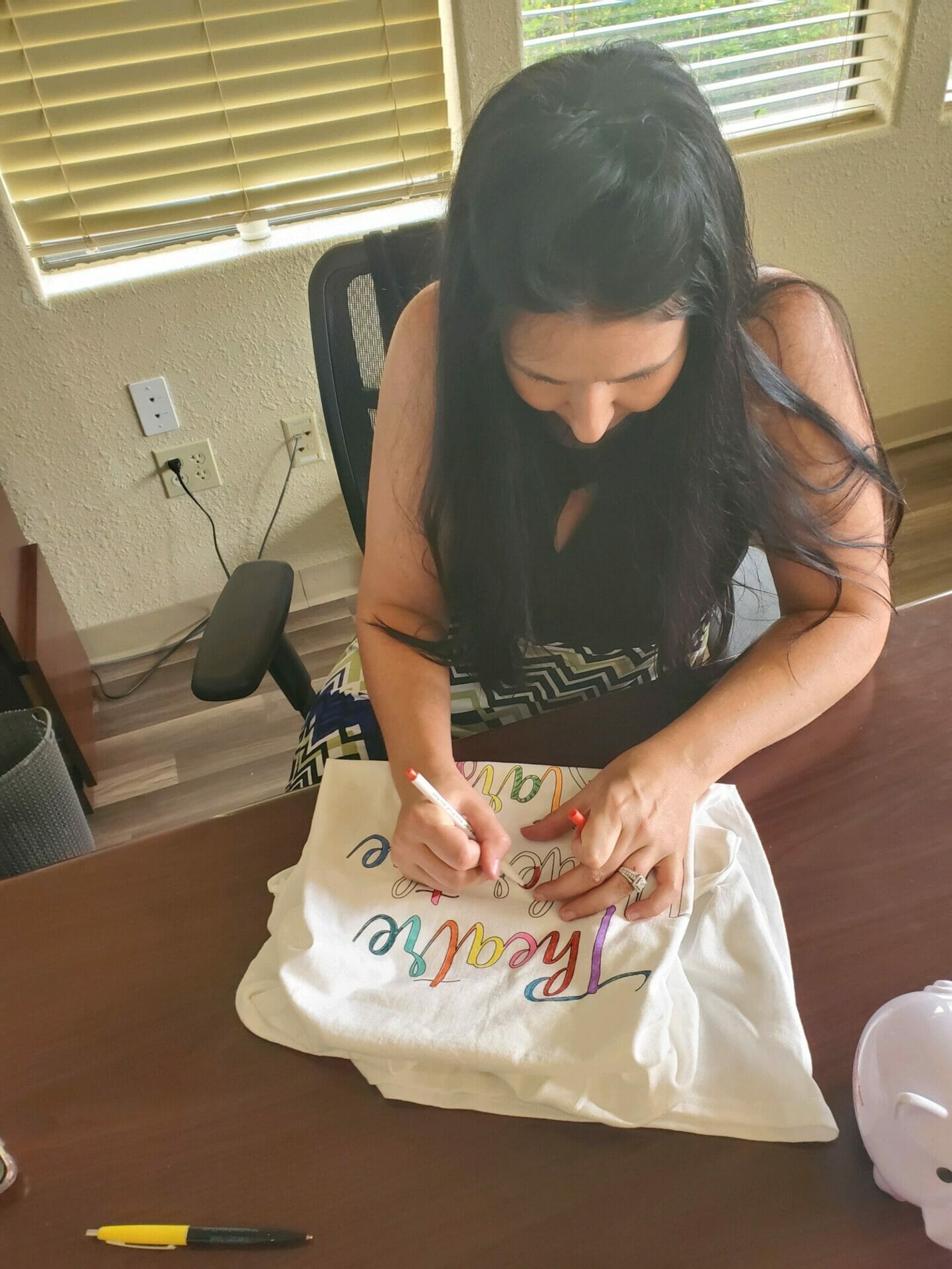 woman coloring a tee shirt with markers