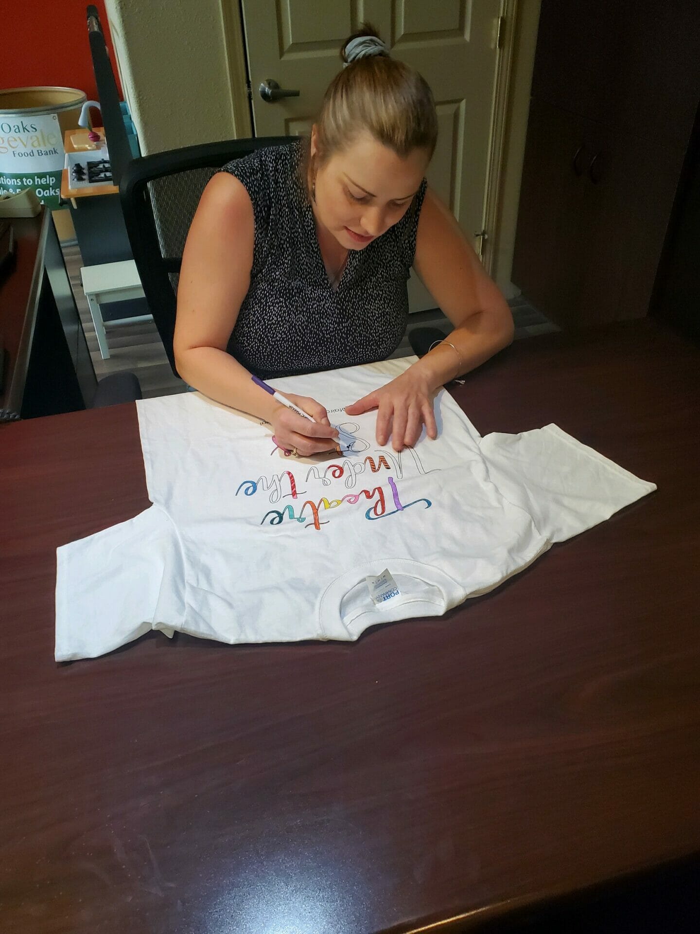 woman coloring tee shirt with markers