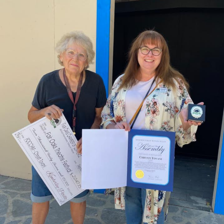 Barbara holding the check that the Fair Oaks Theatre festival received