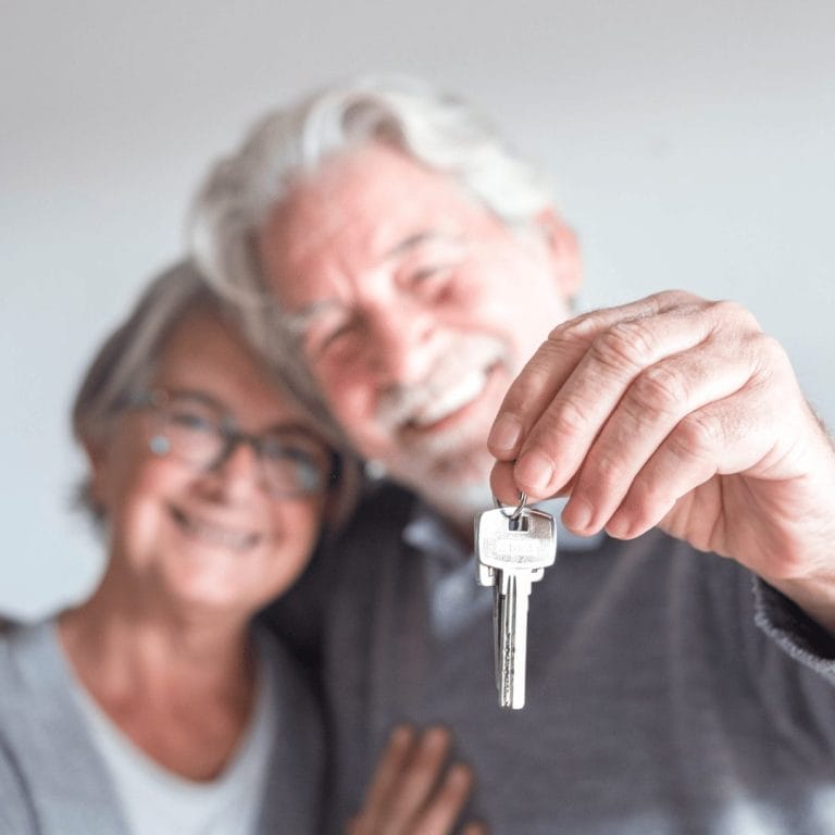 woman and man holding up house keys