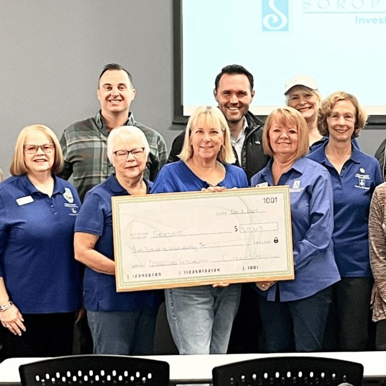 group of people holding a large check
