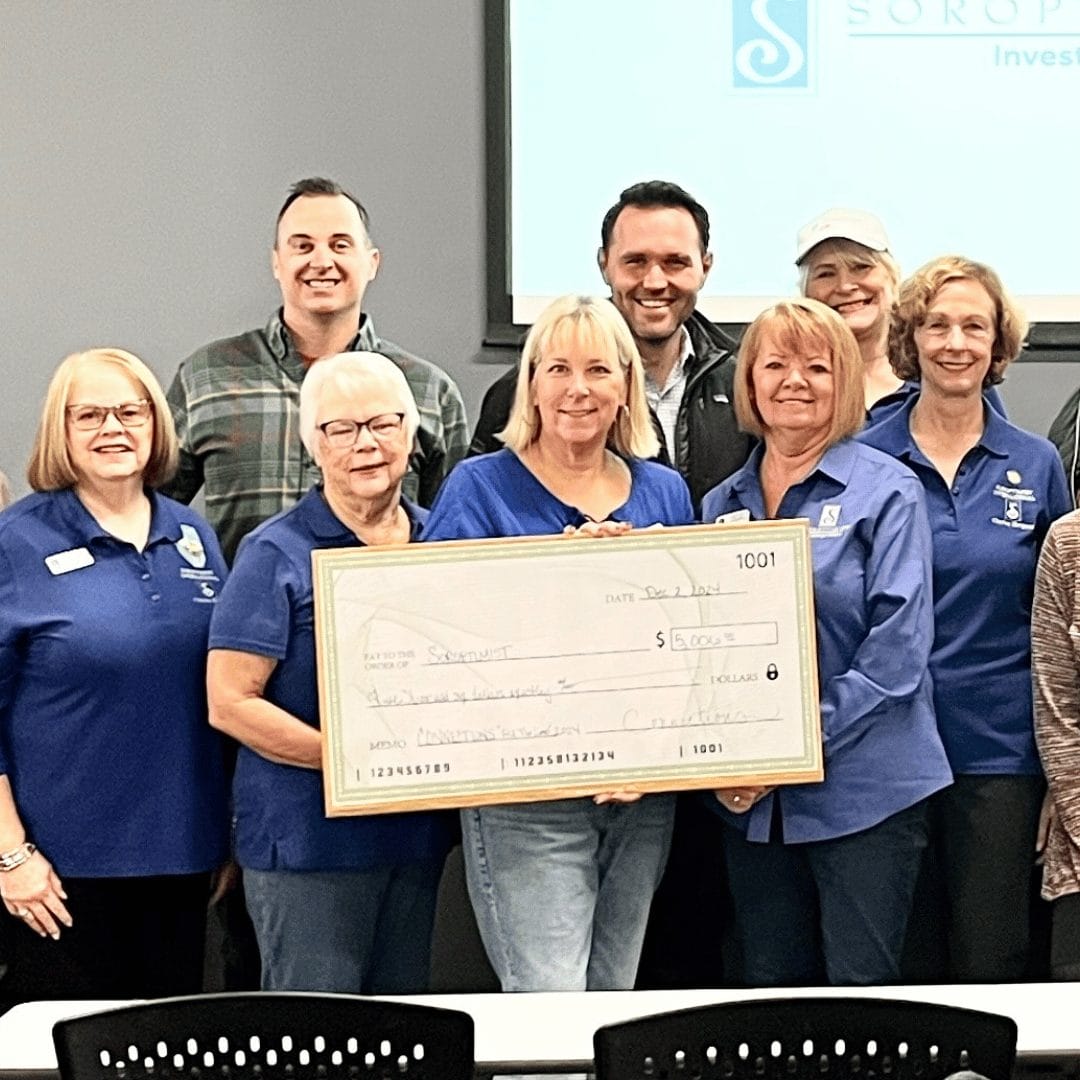 group of people holding a large check