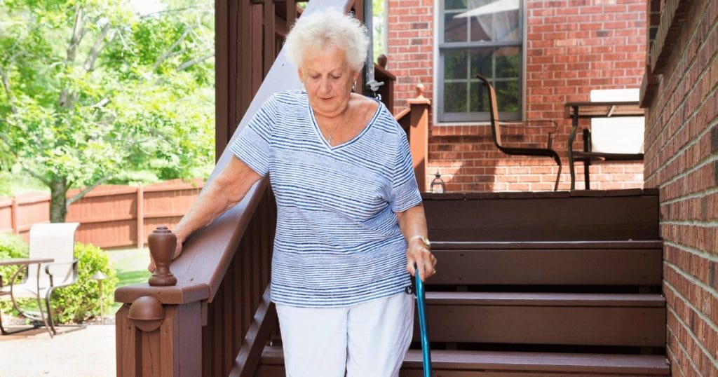 woman with cane walking down stairs
